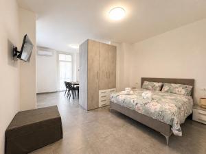 ein Schlafzimmer mit einem Bett und ein Zimmer mit einem Tisch in der Unterkunft Mema Residence in Varallo Pombia