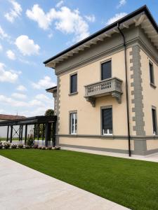 ein großes Haus mit Balkon und Rasen in der Unterkunft Mema Residence in Varallo Pombia