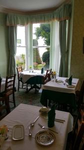 a dining room with two tables and a large window at Bron Orme Private Hotel in Llandudno