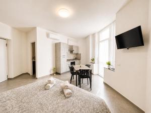 ein weißes Schlafzimmer mit zwei Stofftieren auf einem Bett in der Unterkunft Mema Residence in Varallo Pombia