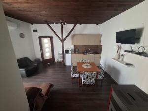 a living room with a table and a kitchen at Apartmani Lovro in Ogulin