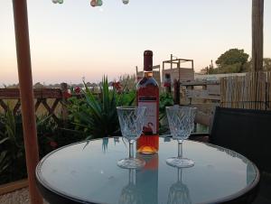 a bottle of wine sitting on a table with two glasses at ON THE SAND apartment in Artemida