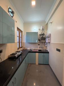 a kitchen with a stove and a counter top at Singh Kainchi Dham Villa in Bhowāli