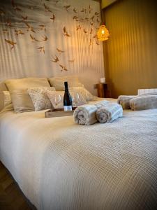 a bed with a bottle of wine and two glasses at Elegance Bretonne in Pléneuf-Val-André