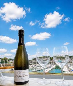 a bottle of wine and two wine glasses on a table at Elegance Bretonne in Pléneuf-Val-André