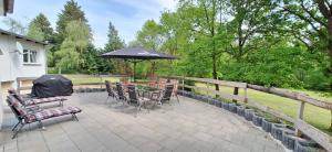 a patio with a table and chairs and an umbrella at Ferienhaus an der Ölmühle in Heusweiler
