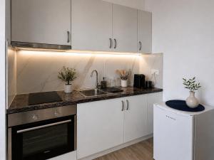 a kitchen with white cabinets and a sink at DoR Stay Seaside in Durrës