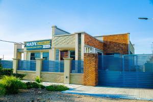 a building with a blue fence in front of it at Nadyapartment in Dodoma
