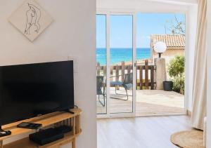 a living room with a television and a view of the ocean at Seaside Apartment in Conca