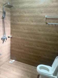 a bathroom with a toilet and a wooden wall at Nadyapartment in Dodoma +6 photos