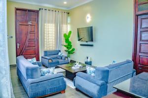 a living room with blue chairs and a table at Nadyapartment in Dodoma