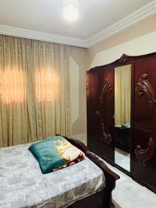 a bedroom with a bed and a dresser at Appartement Al Hanine in Douz