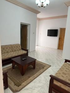 a living room with a couch and a coffee table at Appartement Al Hanine in Douz