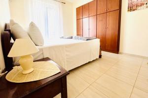 a bedroom with a bed and a table with a lamp at Holiday Dream Thalia Apartment in Mastihari +5 photos