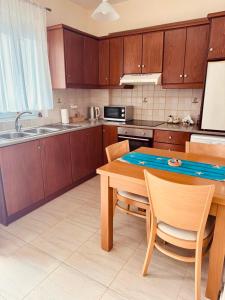 a kitchen with wooden cabinets and a table and chairs at Holiday Dream Thalia Apartment in Mastihari