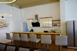 a kitchen with a bar with chairs and a refrigerator at Ostseelandhaus DHH Wendy 1 in Proseken