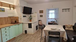 a kitchen and living room with a table and a kitchen and a living room at Agroturystyka całoroczna Ranczo Husinka in Husinka