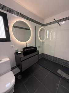 a bathroom with a black sink and a mirror at Corralejo Tender Suite in Corralejo
