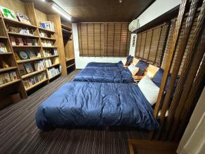 a bedroom with a blue bed and book shelves at 2nd House Family in Akimoto