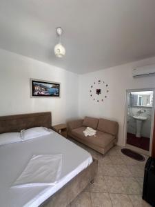 a bedroom with a bed and a couch and a sink at Tony Home in Borsh