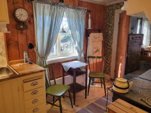 a kitchen with a table and two chairs and a window at Stastugan in Grönhult