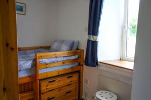 a small bedroom with a bunk bed with a window at Scoor House - Laggan in Bunessan