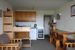a small kitchen with wooden cabinets and a table at Scoor House - Laggan in Bunessan