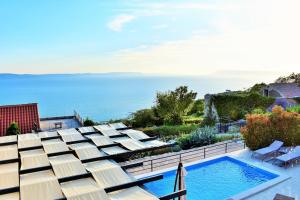 a house with a swimming pool next to the ocean at Villa Vedran in Podgora