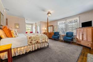 a bedroom with a bed and two blue chairs at Inn at Jackson in Jackson