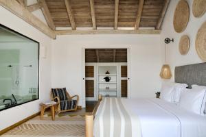 a bedroom with a large bed and a mirror at Quinta Da Comporta - Wellness Boutique Resort in Comporta +38 photos