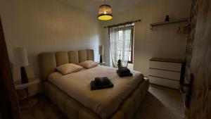 a bedroom with a bed with two black objects on it at Escapade au cœur du Haras in Le Mesnil-Rouxelin