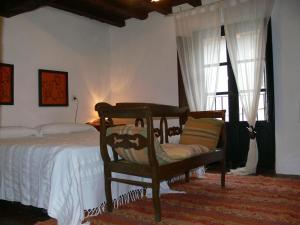 a bedroom with a bed with a chair and a window at Casas Rurales Casas en Batuecas in Villanueva del Conde +109 photos