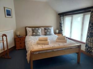 a bedroom with a bed with two pillows on it at Farm Stay with animal experiences, 30 minutes to Exmoor & Beaches, Pet friendly, Outdoor heated pool, Games barn, fast WiFi and parking in Barnstaple