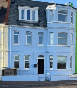a blue house with a black roof at Exmouth Devon Luxurious Flat OverlookingThe Sea in Exmouth