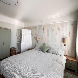 a bedroom with a large white bed and two lamps at Exmouth Devon Luxurious Flat OverlookingThe Sea in Exmouth