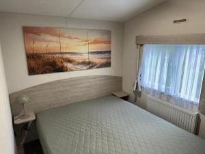 a bedroom with a bed and a painting on the wall at Chalet JT08 in Renesse in Renesse