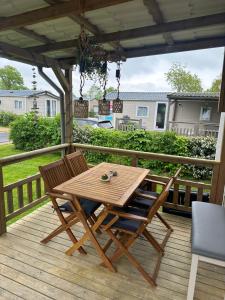 a wooden table and chairs on a deck at Chalet JT08 in Renesse in Renesse