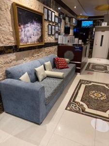 a blue couch in a room with a wall at رمادان تربة للشقق المخدومة in Turbah