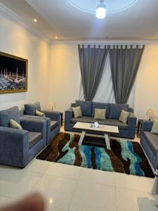 a living room with two couches and a coffee table at رمادان تربة للشقق المخدومة in Turbah
