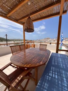 a wooden table and chairs on a patio at La Casa Bianca Naxos in Vívlos