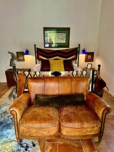 a brown leather couch in a living room with a piano at Lo Smarrino agriturismo in Gubbio