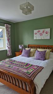 a bedroom with a large bed with purple pillows at Luachra Lodge in Killarney