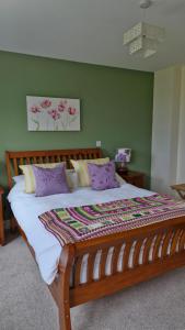 a bedroom with a large wooden bed with purple pillows at Luachra Lodge in Killarney