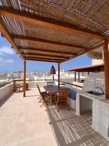 a wooden patio with a table and chairs on a roof at La Casa Bianca Naxos in Vívlos