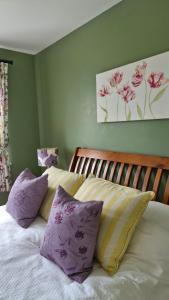 a bedroom with a bed with purple and yellow pillows at Luachra Lodge in Killarney