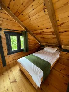 a bedroom with a bed in a wooden cabin at Pisa Villa-Bungalov in Topluca