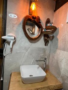 a bathroom with a sink and a mirror on the wall at Pisa Villa-Bungalov in Topluca