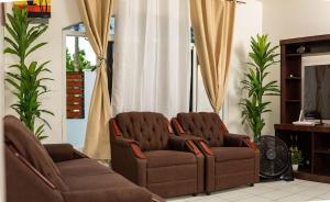 two chairs and a couch in a living room at Casa Herminia in Omoa