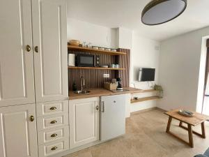 a kitchen with white cabinets and a microwave at Entre Murallas in Doña Mencía