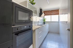 a kitchen with a sink and a microwave at ApartRincón Candelaria in Rincón de la Victoria